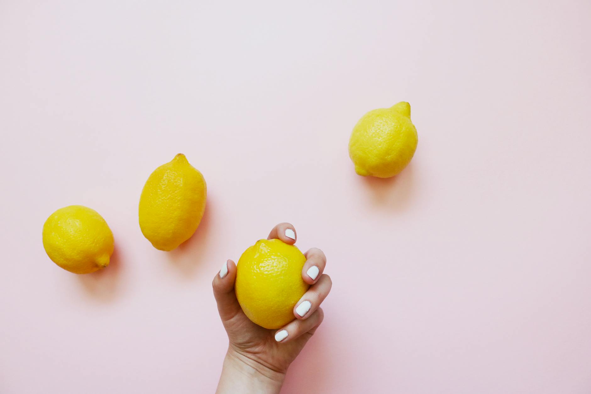 A close-up of a hand holding an orange vibrator against a minimalistic purple backdrop, showcasing modern sensuality.
